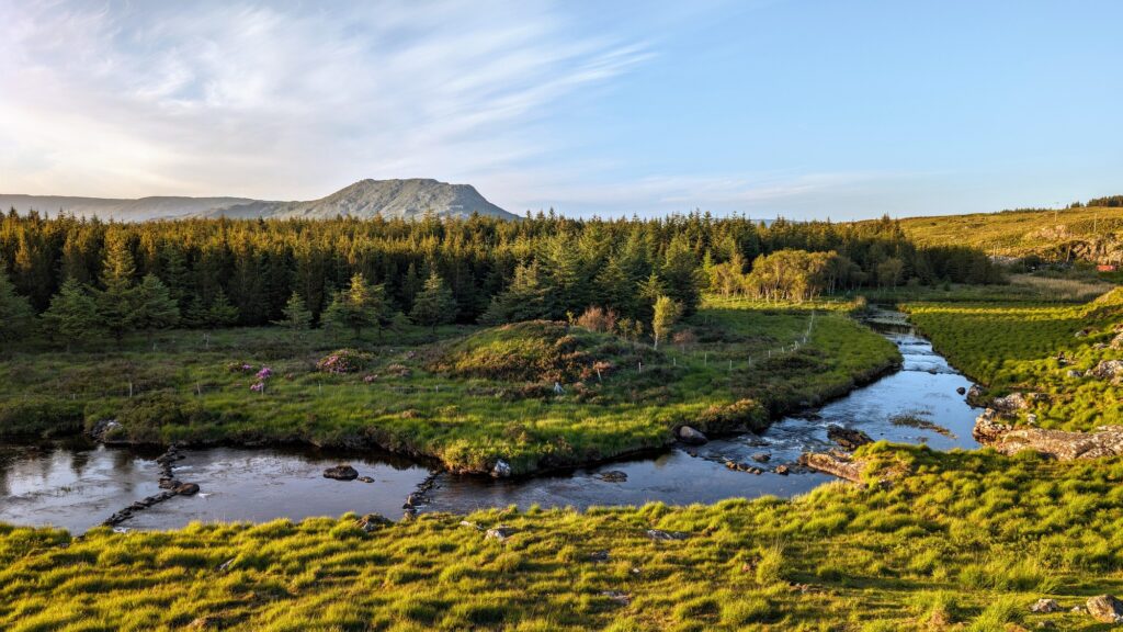 Beautiful landscape scenery with green hills, river and mountains at Connemara National park in Coun